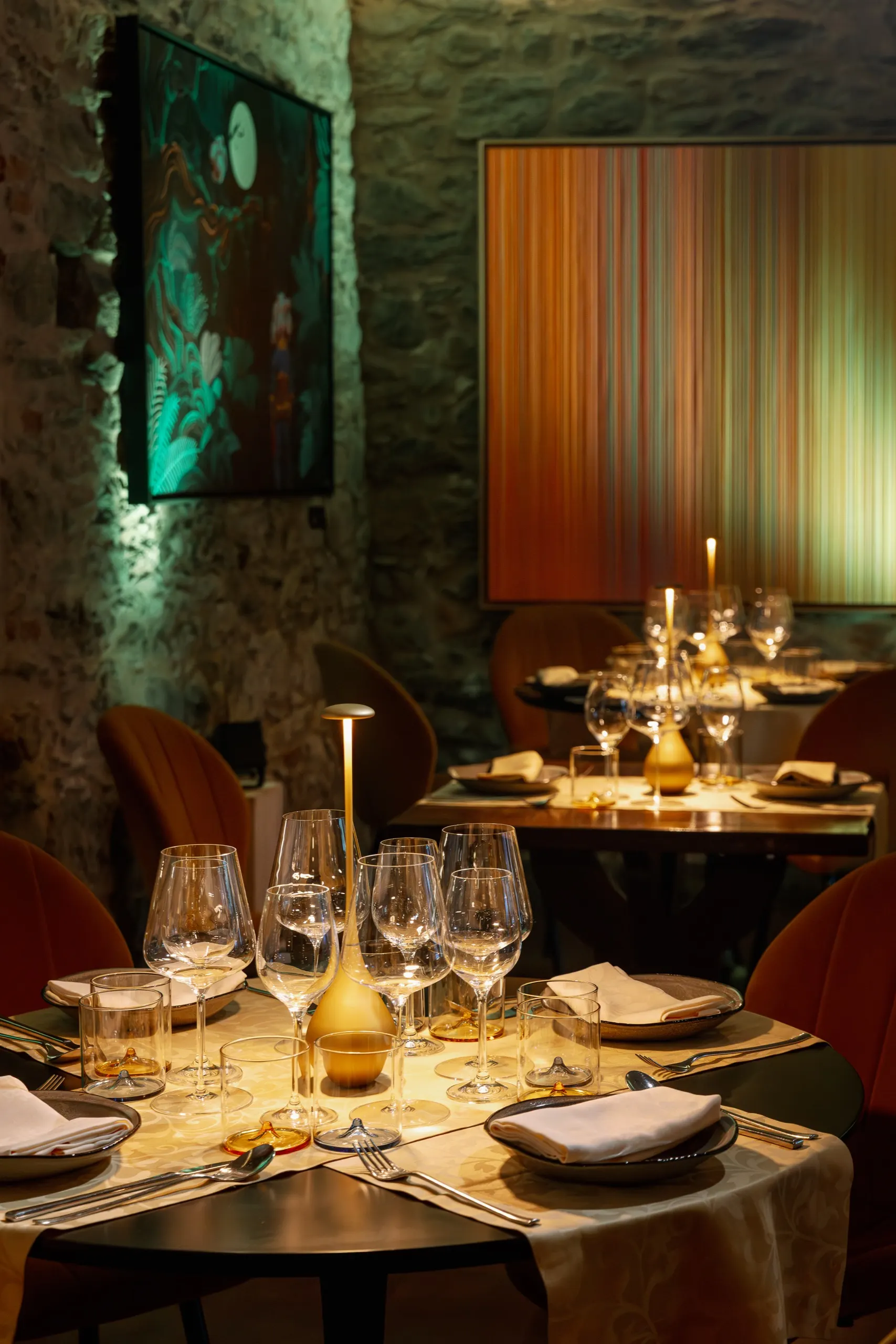 Stone dining room with illuminated artworks on the walls